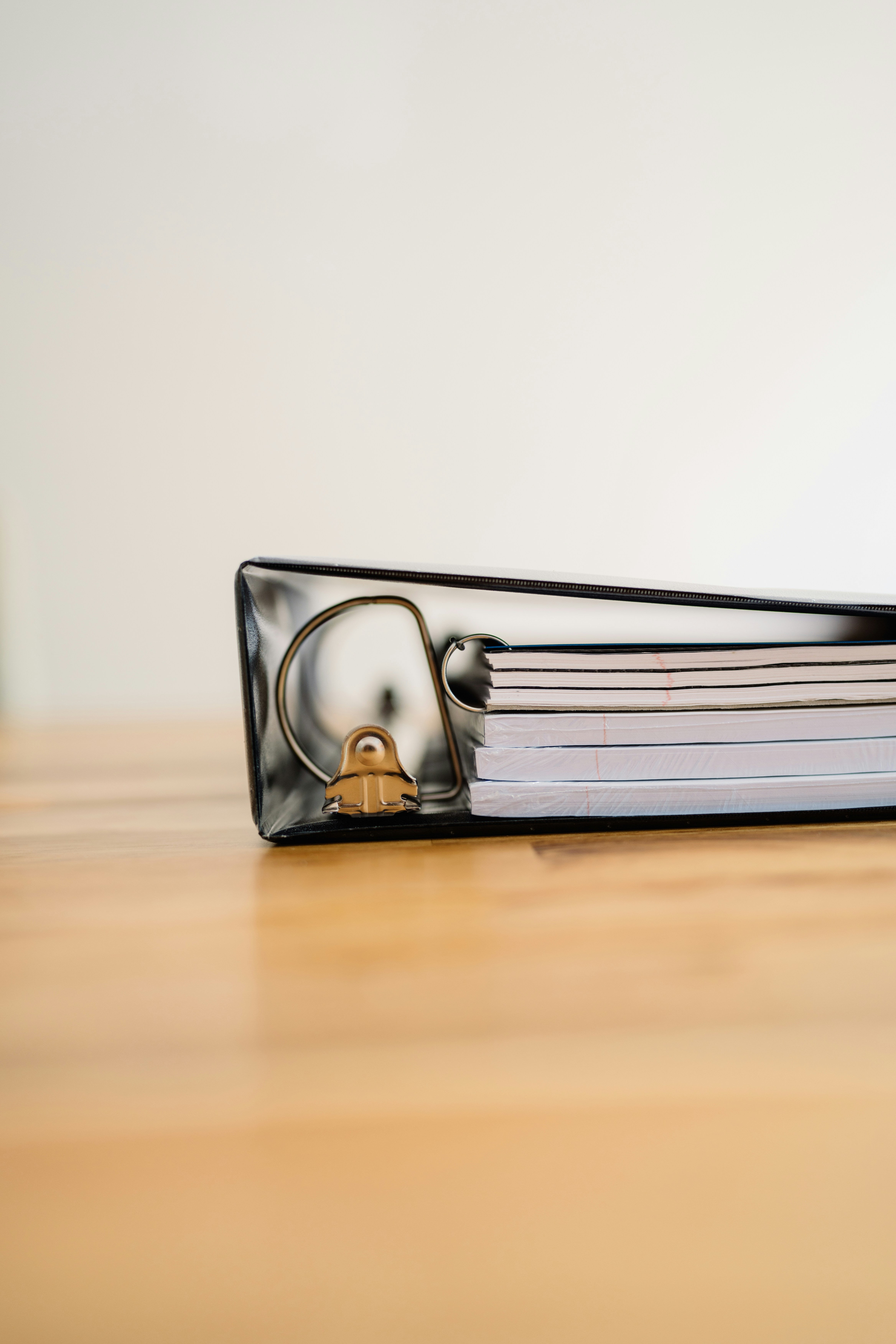 A thick binder lying on a wooden surface